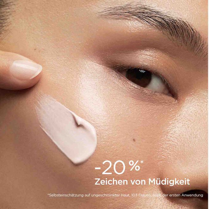 Frau mit Texturklecks SOS Primer Pink von Clarins auf der Wange, um zu zeigen, dass er Müdigkeitszeichen um 20 % reduziert.