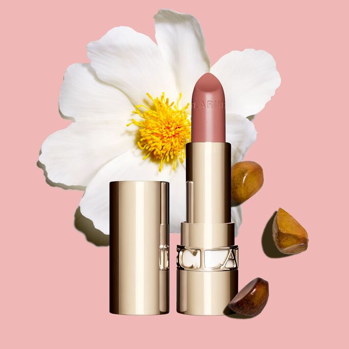 Joli Rouge Lippenstift von Clarins vor einer Kamelienbl&uuml;te auf wei&szlig;em Hintergrund