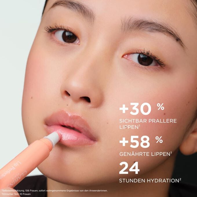 Eine Frau tr&auml;gt den Plumping Lip Perfector auf, der die Lippen voller und gepflegter erscheinen l&auml;sst und 24&nbsp;Stunden lang Feuchtigkeit spendet.