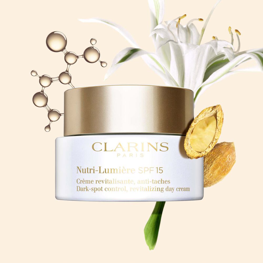 Tiegel der Creme Nutri-Lumière SPF 15 bei Pigmentflecken vor Niacinamid-Molekül, Strandlilie und Wüstendattel.