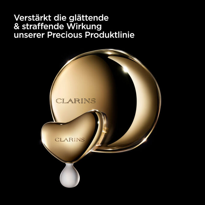Clarins Precious La Lotion mit einem Text, der die Feuchtigkeit spendende, glättende und aufpolsternde Wirkung hervorhebt.