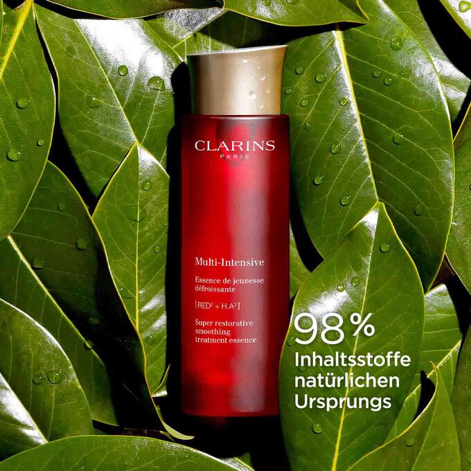 Clarins Multi-Intensive Essence de jeunesse inmitten von Harongablättern mit Text,  98% Inhaltsstoffe natürlichen Ursprungs