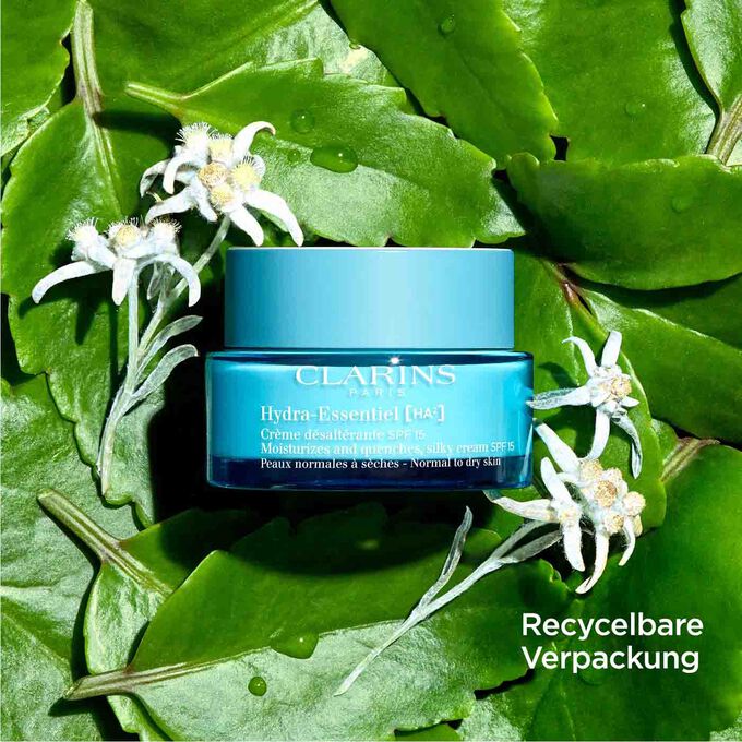 Clarins Hydra-Essentiel Creme SPF15 zwischen Blättern und Edelweißblüten mit Text, der die recycelbare Verpackung hervorhebt