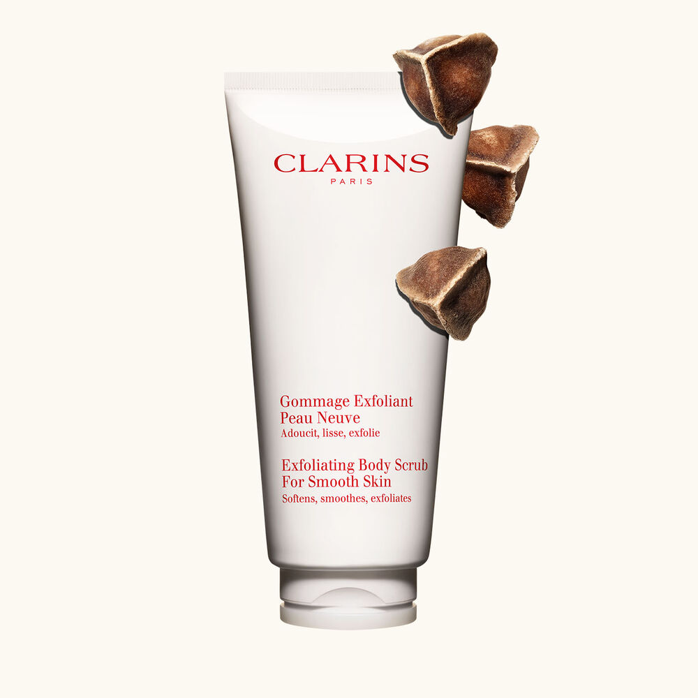 Tube Clarins Gommage Exfoliant Peau Neuve neben Moringa-Samen auf einem beigen Hintergrund