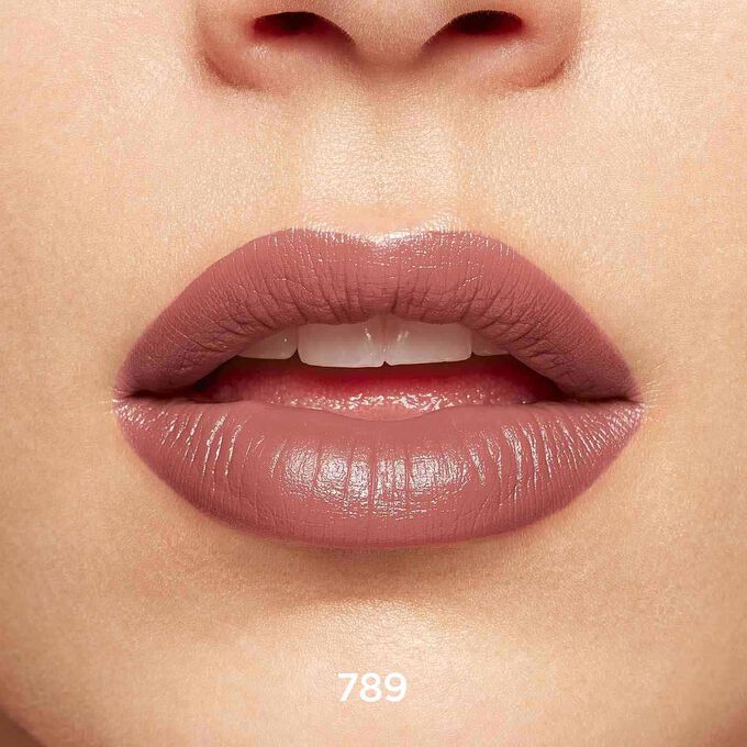 Nahaufnahme von lächelnden Lippen, die Textur und Farbe des Joli Rouge-Lippenstifts in Mocha nude bei hellem Hautton zeigen