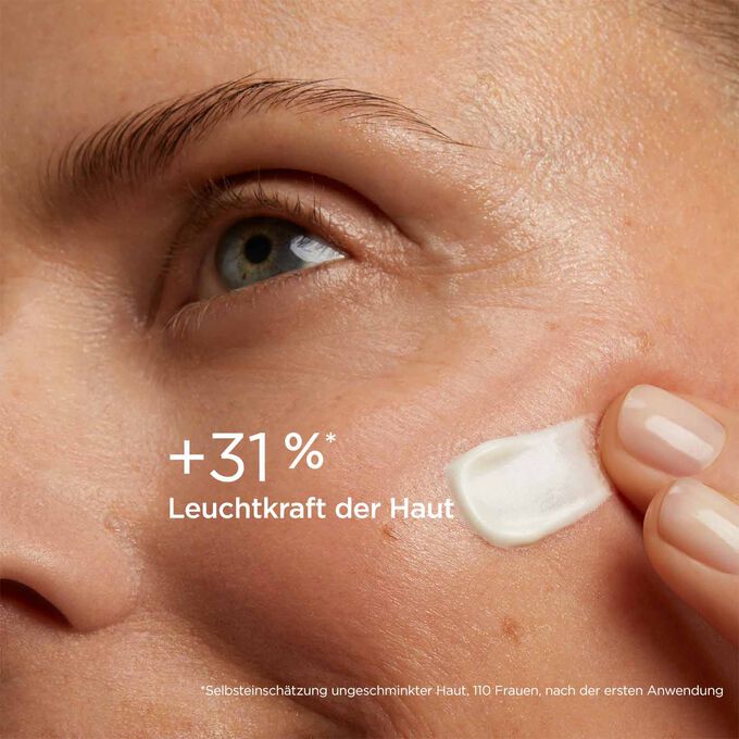 Frau mit Texturklecks SOS Primer White von Clarins auf der Wange, um zu zeigen, dass er die Leuchtkraft der Haut um 31% verbessert