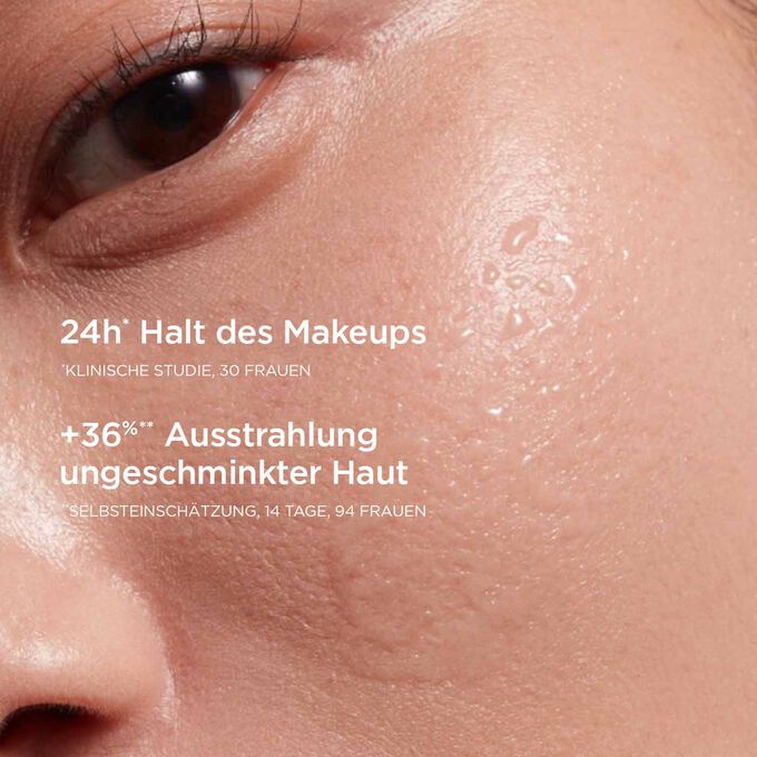 Frauenwange mit einigen Tropfen, die den 24-Stunden-Halt des Makeups und die schöne Ausstrahlung der Haut veranschaulicht.