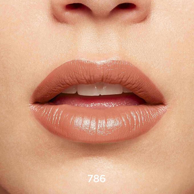 Nahaufnahme von lächelnden Lippen, die Textur und Farbe des Joli Rouge-Lippenstifts in Beige nude bei hellem Hautton zeigen