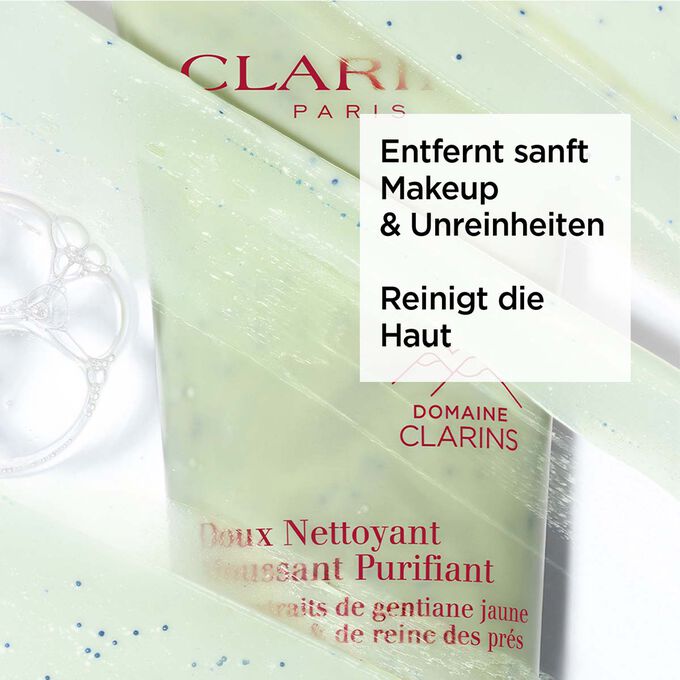 Grüne Tube von Clarins Doux Nettoyant Moussant Purifiant unter Schaum mit Text über seine klärende Wirkung