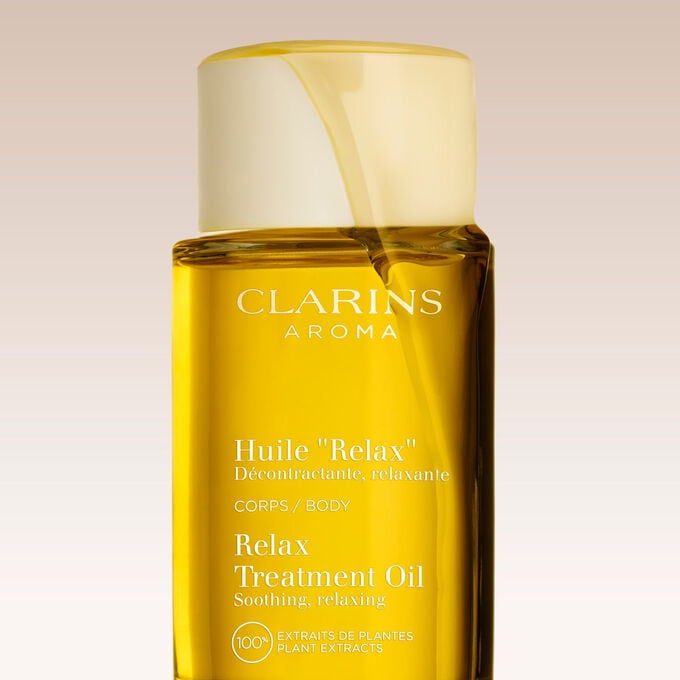 Clarins Huile Relax auf einem strukturierten Hintergrund, mit Text, der die entspannende Wirkung des Produkts hervorhebt