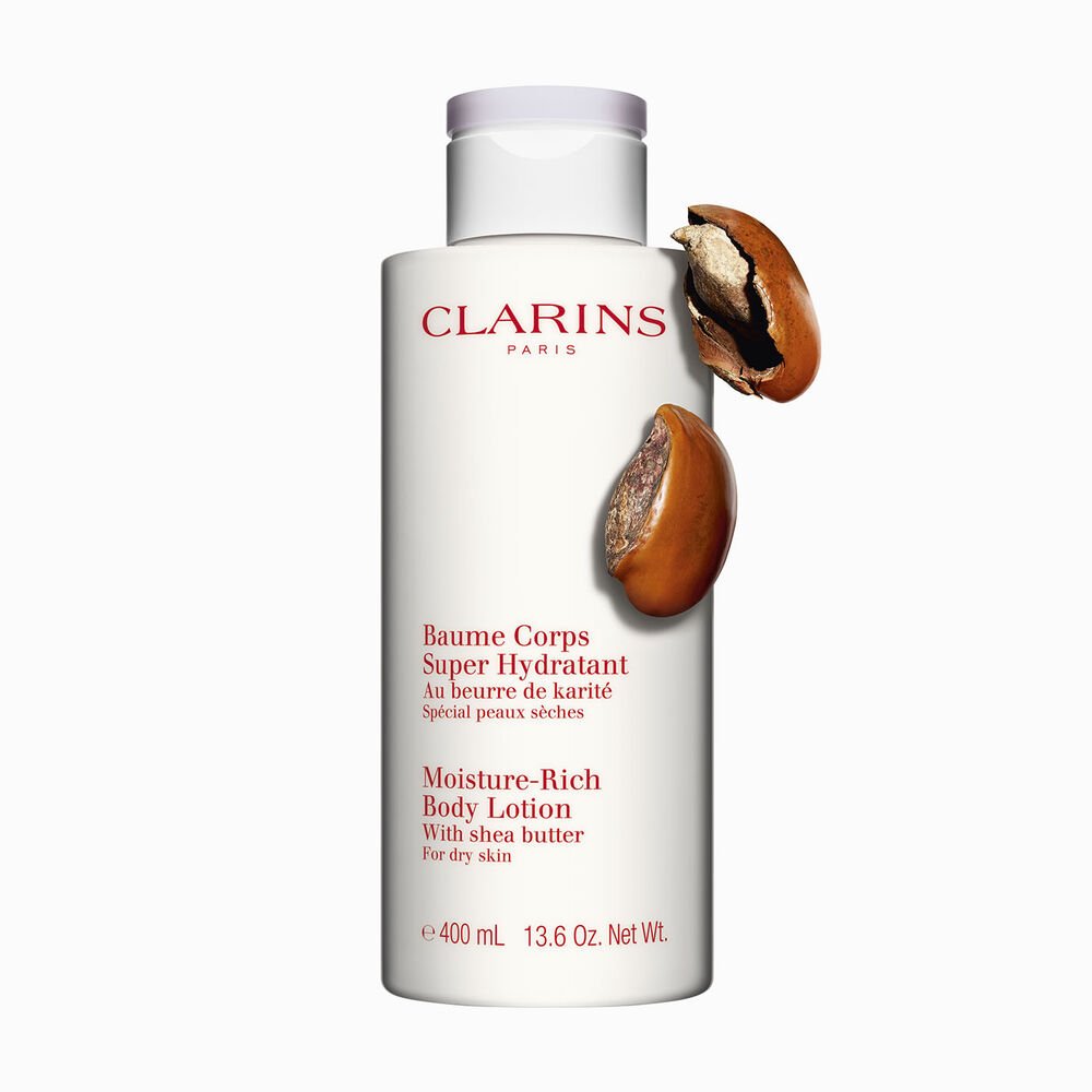 Flakon Clarins Body Lotion Baume Coprs Super Hydratant mit zwei Sheanüssen auf weißen Hintergrund