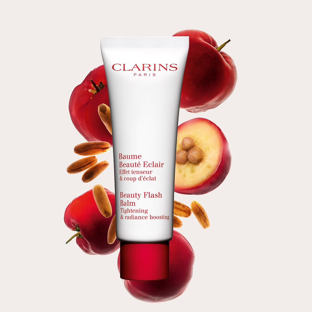Tube Clarins Baume Beaut&eacute; Eclair mit Acerolakirschen auf pfirsichfarbenem Hintergrund