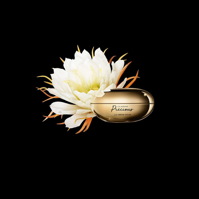 Clarins Precious La Crème Riche vor der Blüte der Königin der Nacht auf schwarzem Hintergrund