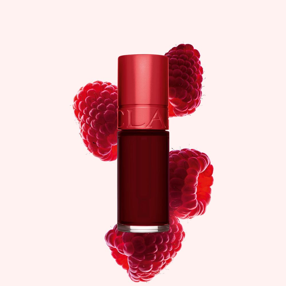 Clarins Lip Stain Shade 09 deep red water neben Himbeeren auf einem hellrosa Hintergrund.