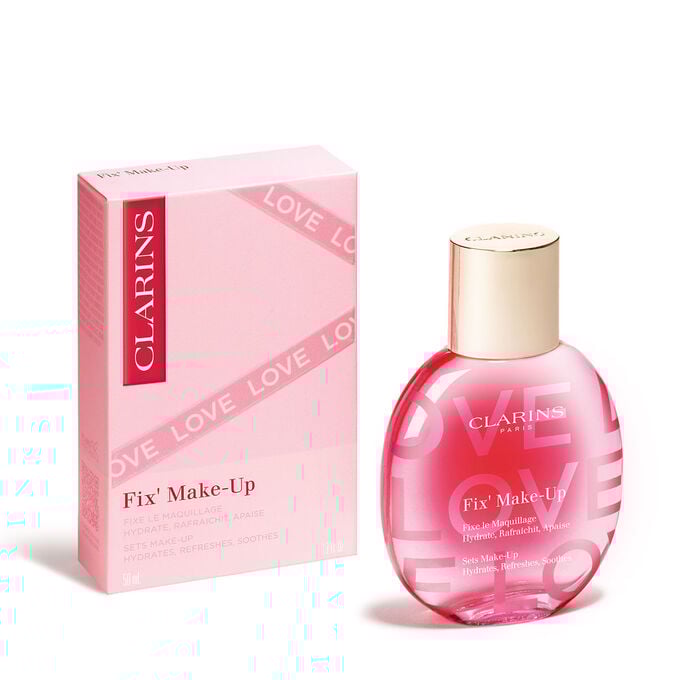 Flakon des Fix Make-Up Spray aus der Love Collection in limitierter Edition und seiner Verpackung, wobei die lebendige Farbe und das elegante Design herausgestellt werden