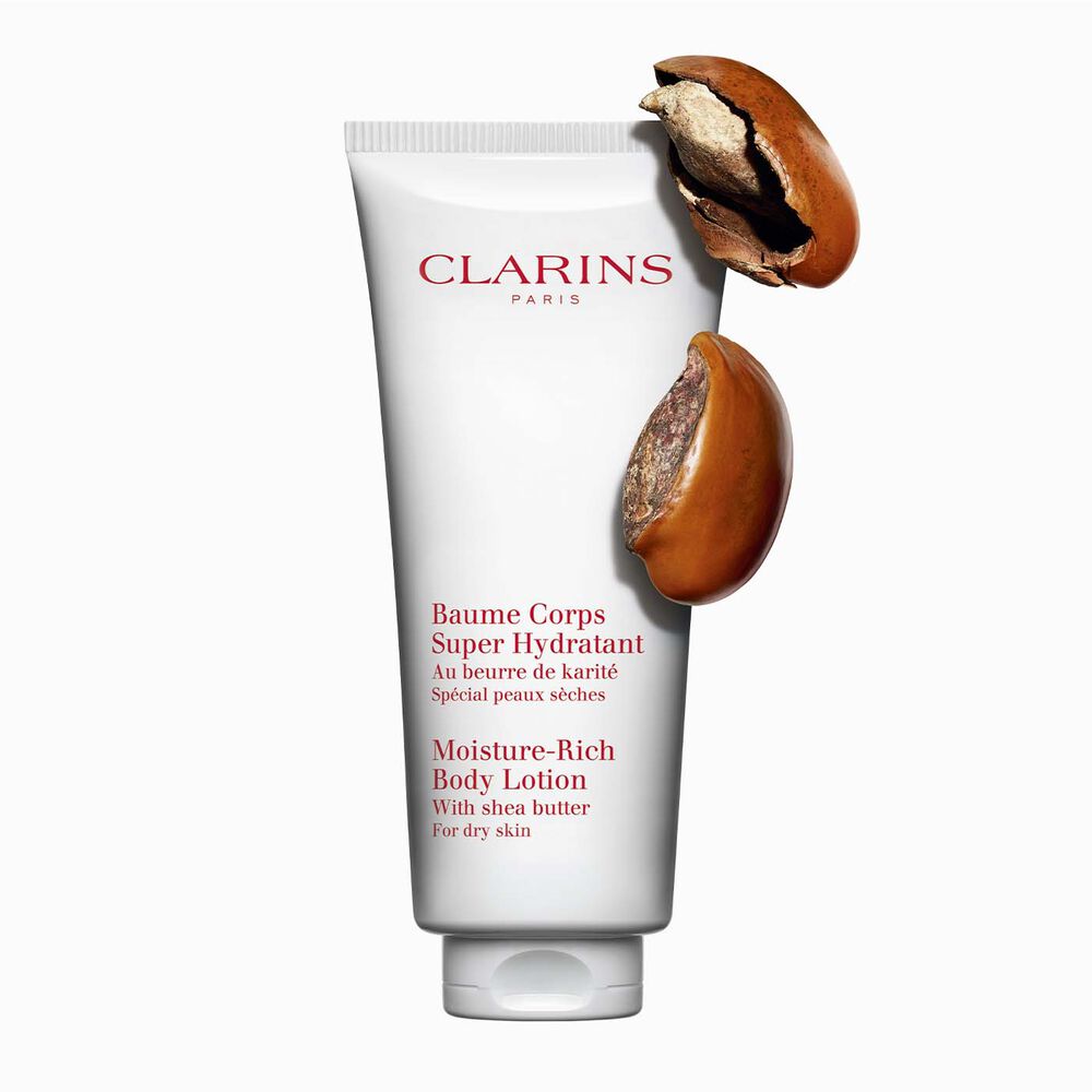 Flakon Clarins Body Lotion Baume Coprs Super Hydratant mit zwei Sheanüssen auf weißen Hintergrund