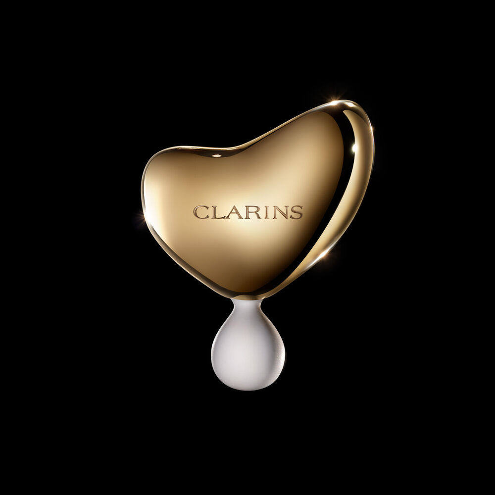 Clarins Precious La Lotion vor der Blüte der Königin der Nacht auf schwarzem Hintergrund