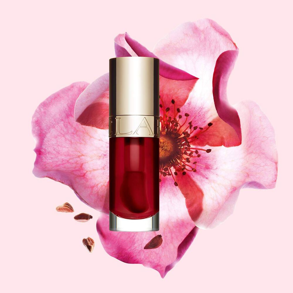 Clarins Lip Comfort Oil 03 Cherry mit pflegender Wirkung vor einer Weinrose, um die natürlichen Inhaltsstoffe hervorzuheben
