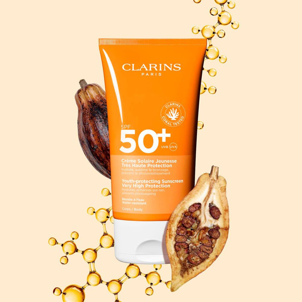 Tube Clarins Crème Solaire Jeunesse SPF 50 für den Körper, zwischen Kollagenmolekülen und Kakaobohnen.