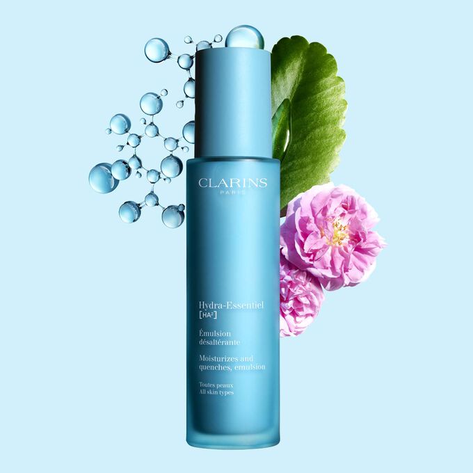 Clarins Hydra-Essentiel Emulsion désaltérante inmitten Damaszener Rose und Goethe-Pflanze auf blauem Hintergrund