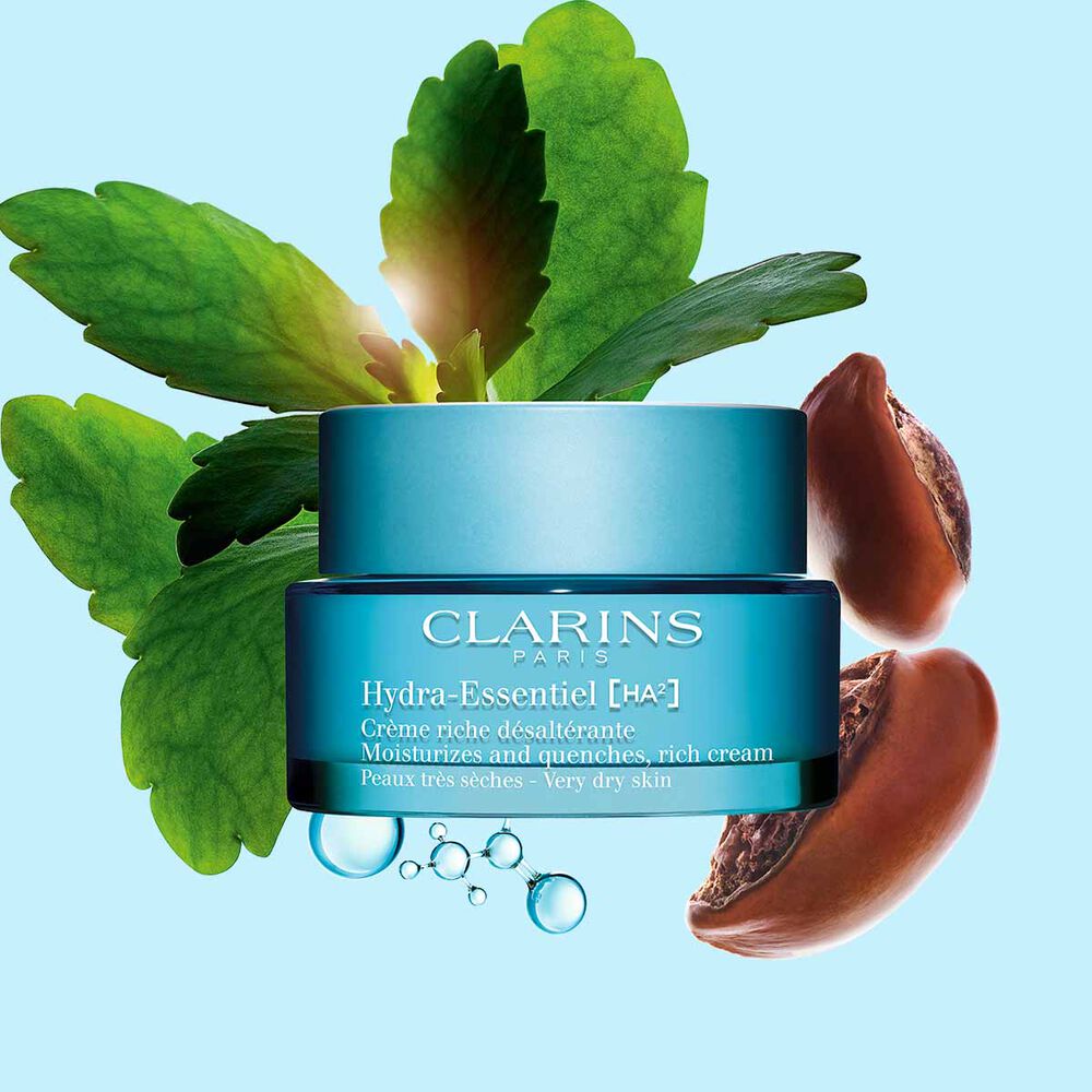 Clarins Hydra-Essentiel Crème riche désaltérante mit Hyaluronsäurekomplex und Sheabutter auf blauem Hintergrund.