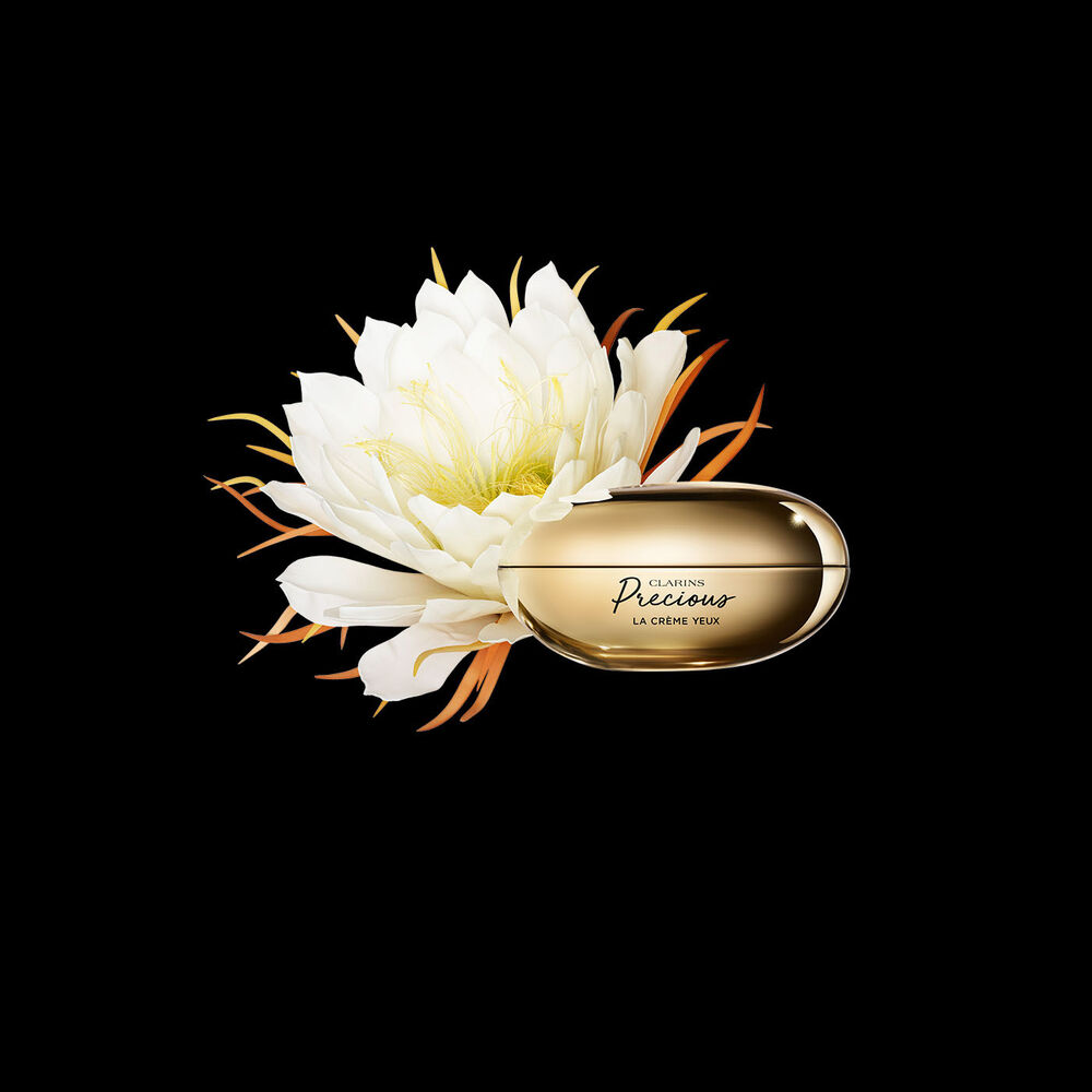 Clarins Precious La Crème Yeux vor der Blüte der Königin der Nacht auf schwarzem Hintergrund