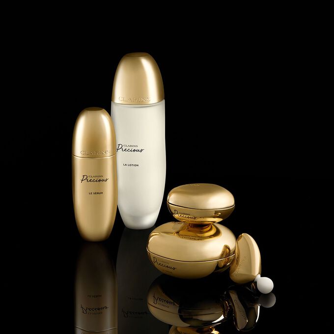 Clarins Precious Luxuspflegelinie auf schwarzem Hintergrund symbolisiert die perfekte Anti-Aging Routine
