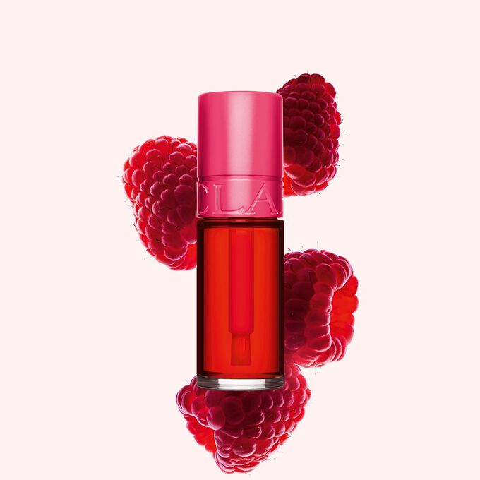 Clarins Water Lip Stain in der Farbe 01 rose water, neben Himbeeren auf einem zartrosa Hintergrund.