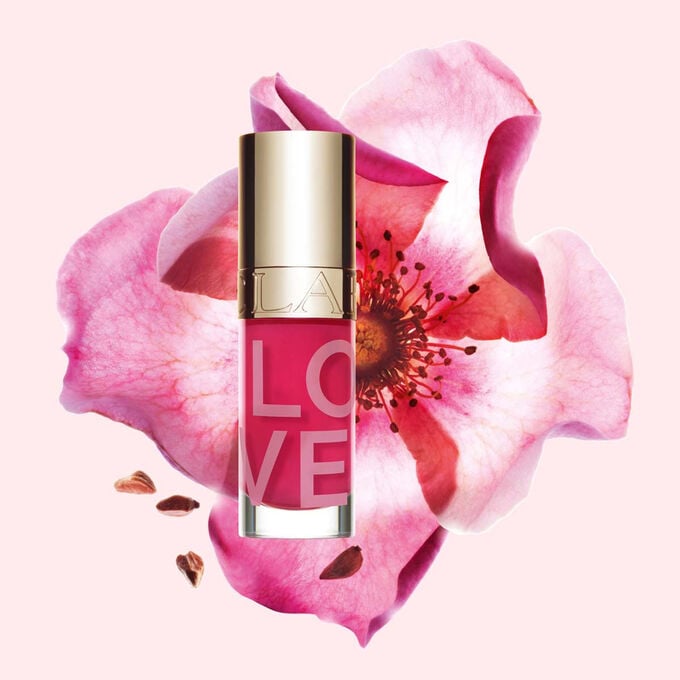 Packshot Lip Oil der Love Collection in limitierter Edition vor einer Rose auf hellrosa Hintergrund
