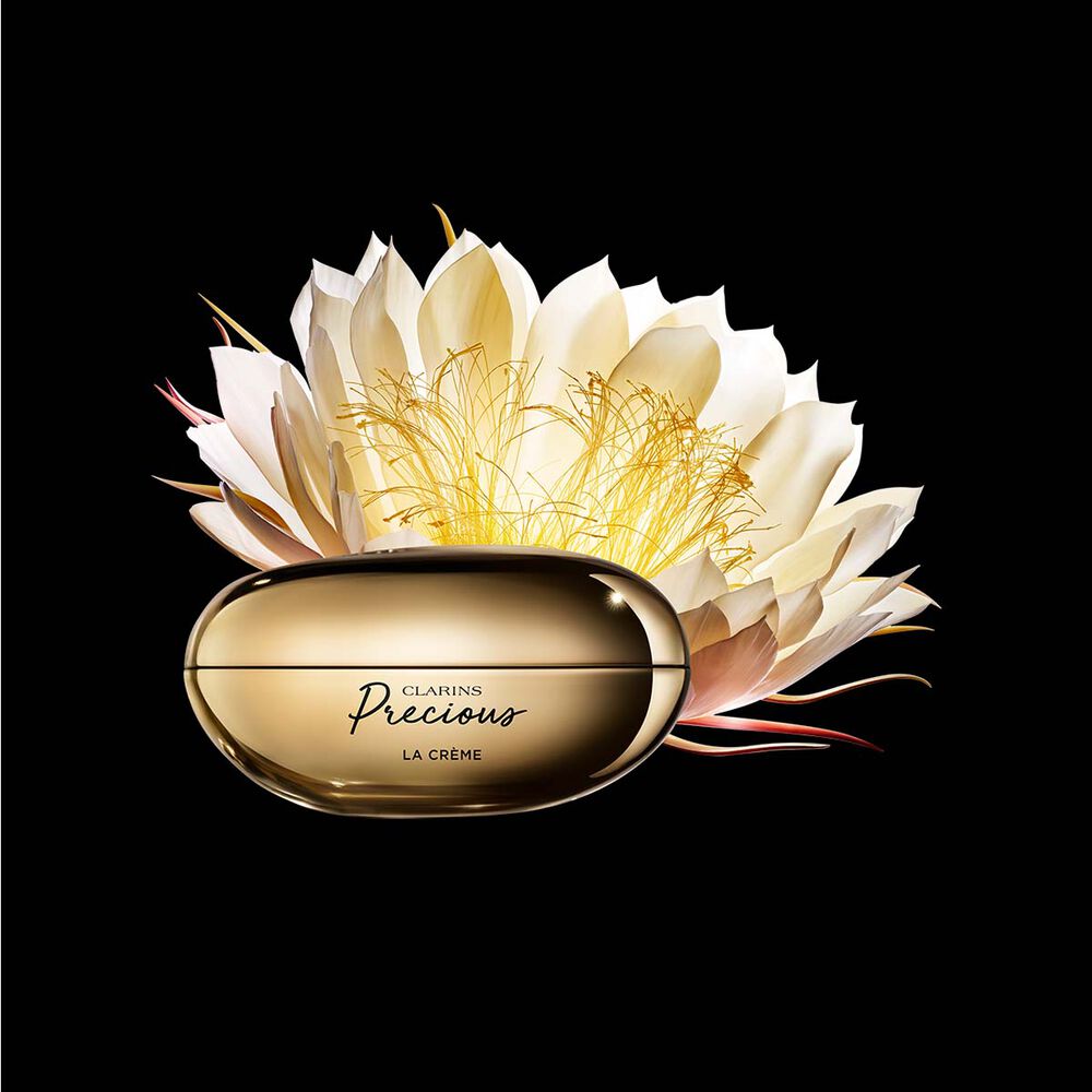 Tiegel Precious La Cr&egrave;me auf schwarzem Hintergrund mit der Bl&uuml;te der K&ouml;nigin der Nacht