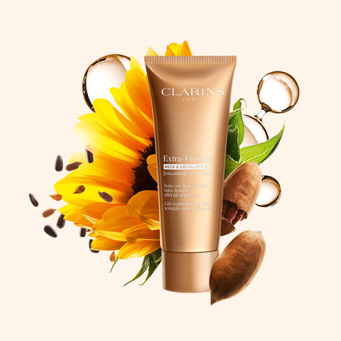 Tube Clarins Firming Neck & D&eacute;collet&eacute; Creme inmitten von Kollagen, Pekann&uuml;ssen und Sonnenblume, um die Aktivstoffe zu zeigen