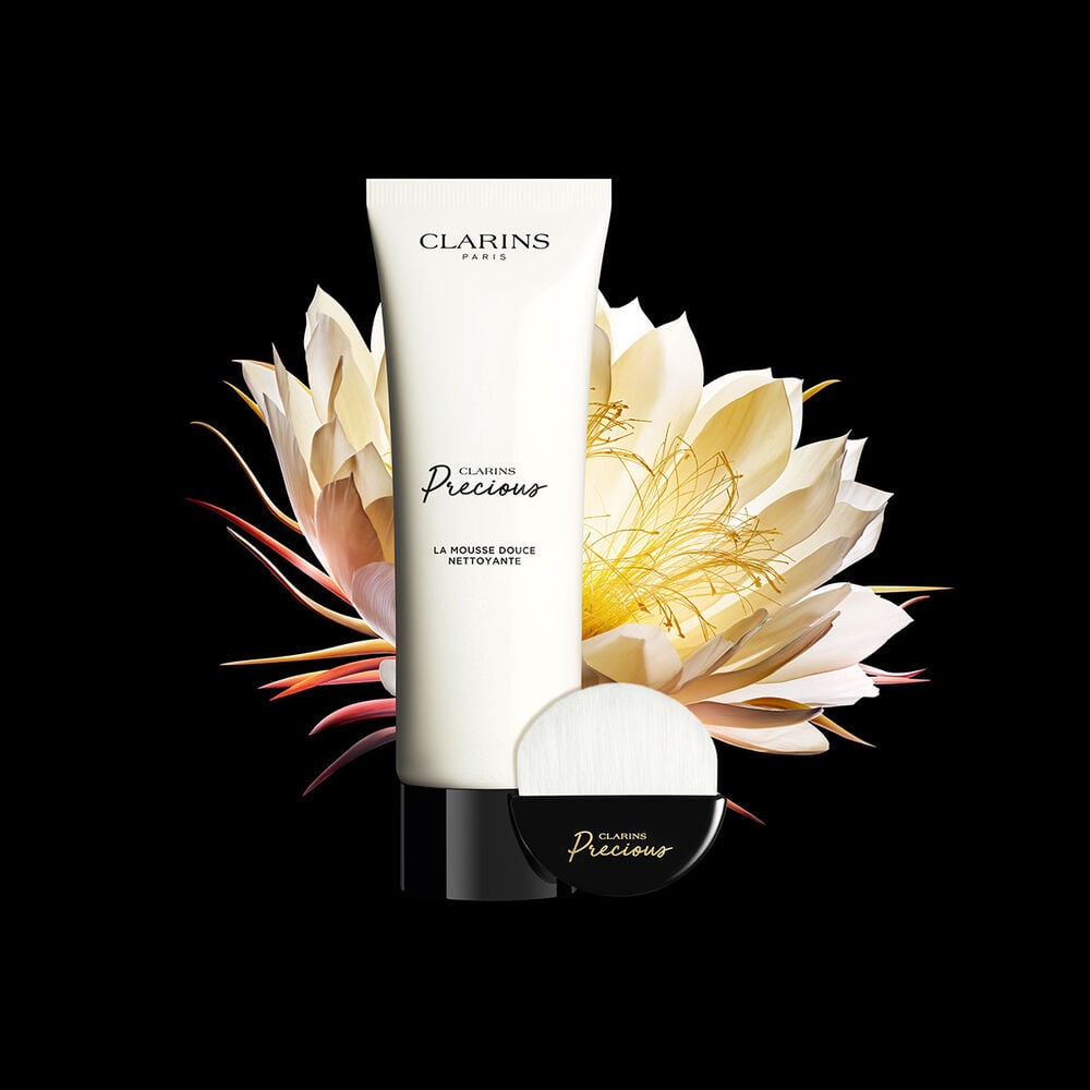 Clarins Precious La Mousse Douce auf schwarzem Hintergrund und vor der Bl&uuml;te der K&ouml;nigin der Nacht