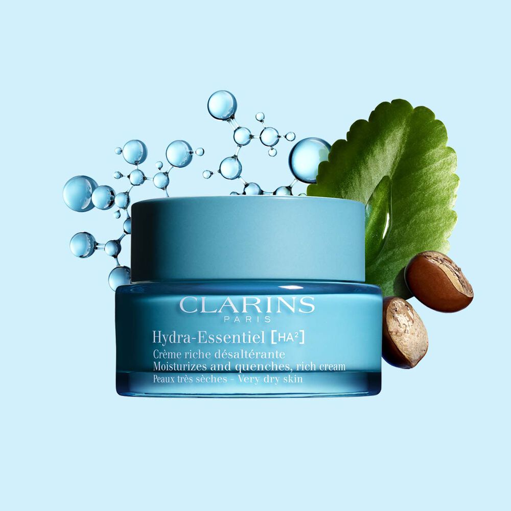 Clarins Hydra-Essentiel Crème riche désaltérante mit Hyaluronsäurekomplex und Sheabutter auf blauem Hintergrund.