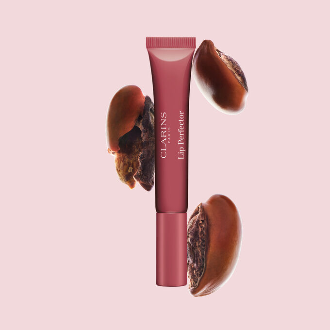 Tube Plumping Lip Perfector neben Sheasamen, um die intensive Lippenpflegeformel f&uuml;r n&auml;hrende Pflegewirkung hervorzuheben