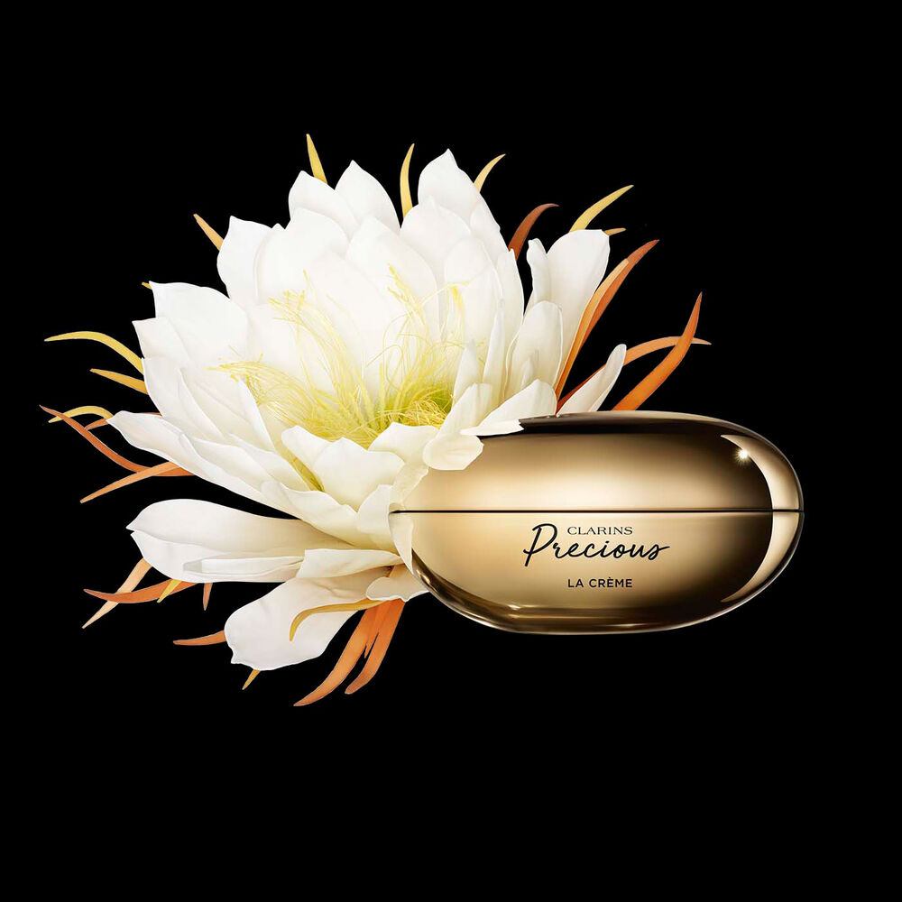Clarins Precious La Crème vor der Blüte der Königin der Nacht auf schwarzem Hintergrund
