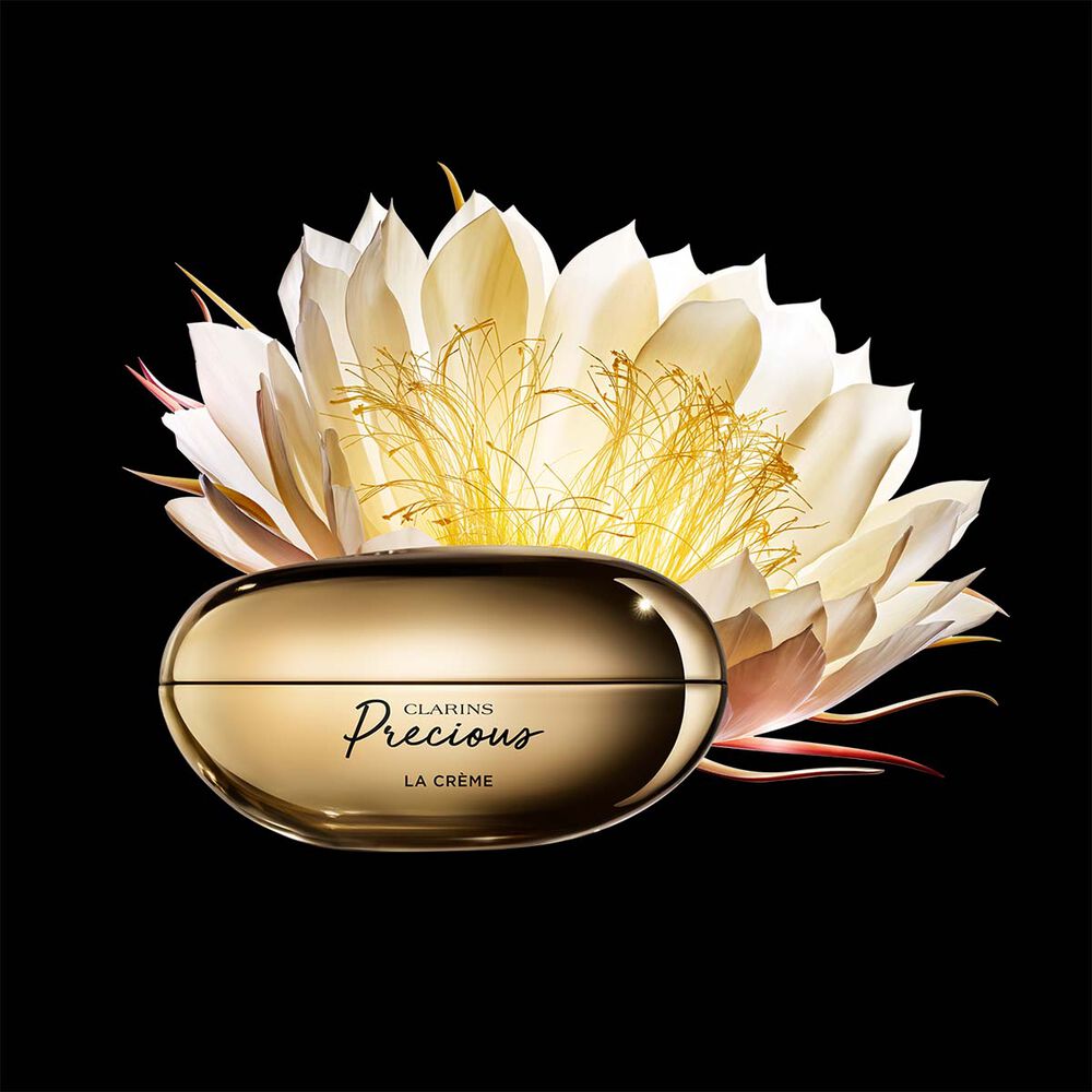 Clarins Precious La Crème vor der Blüte der Königin der Nacht auf schwarzem Hintergrund