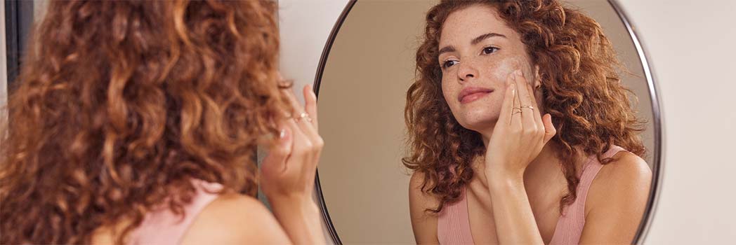 Frau cremt ihr Gesicht ein