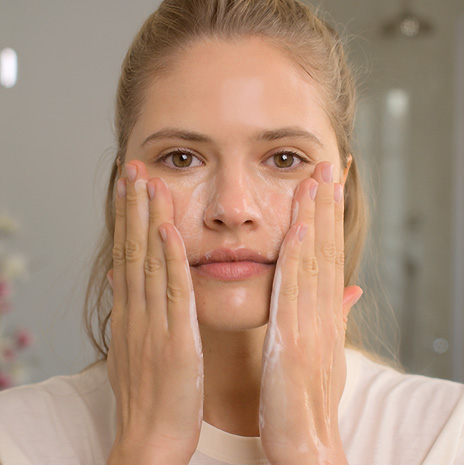 Eine Frau, die ihr Gesicht reinigt